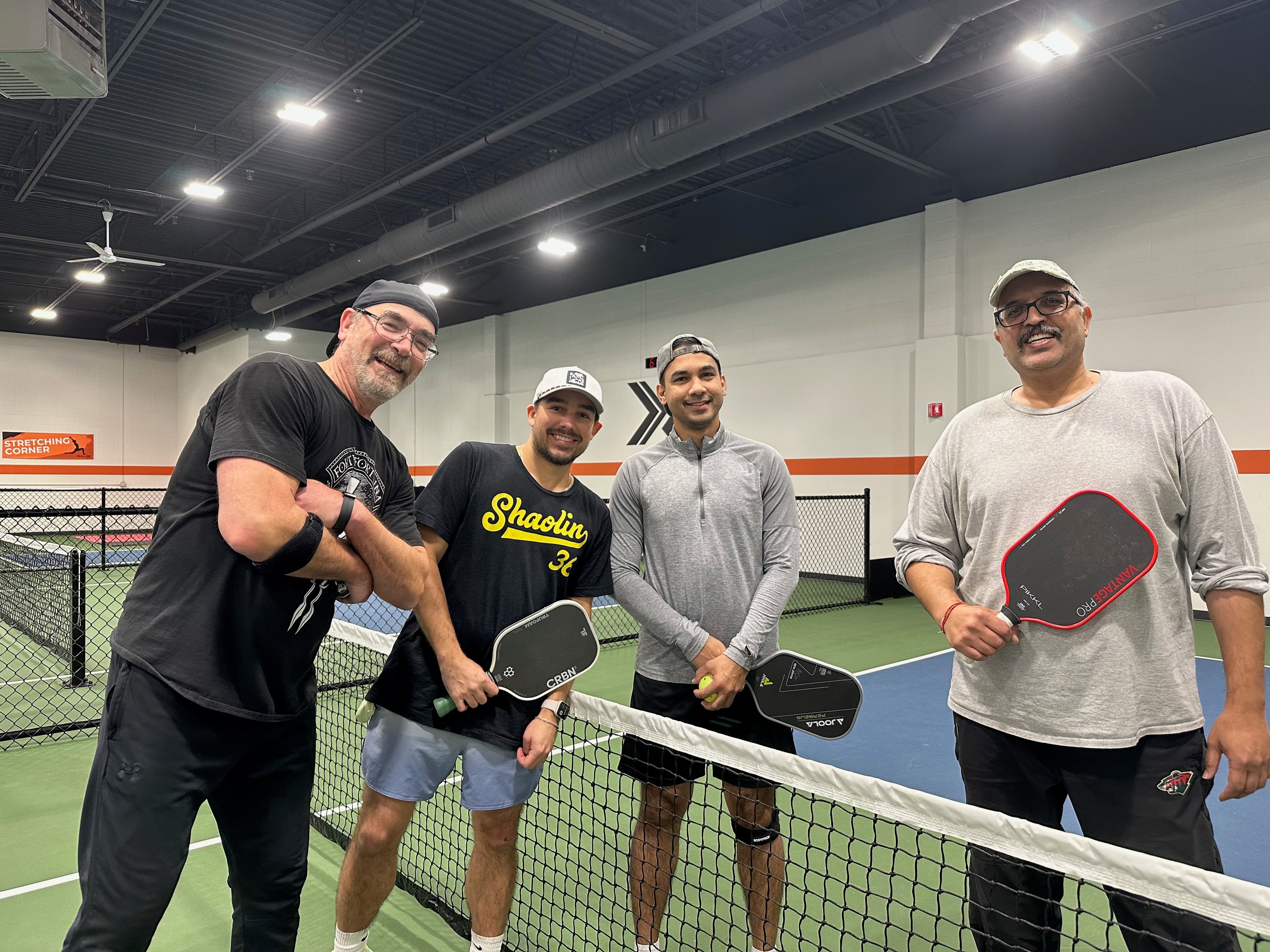 Four pickleball players posing with paddles at PickleX Plymouth